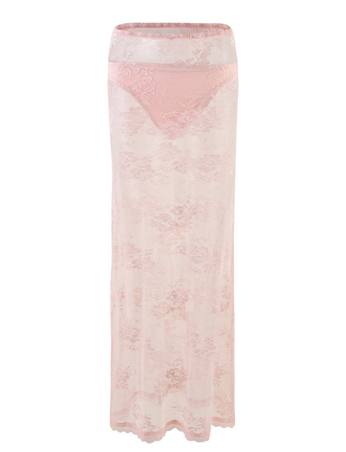 The XADIE SKIRT in pastel pink from TIGERMIST features a high waistband and a sheer lace design. This floor-length skirt boasts an intricate floral pattern, accompanied by a matching pink lining that covers the hip area, offering an elegant and delicate appearance.