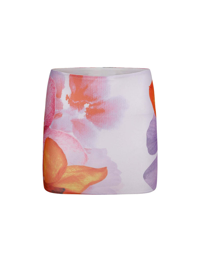 A multi-colored mini skirt with a vibrant floral design by TigerMist. The design features large, abstract flowers in shades of red, orange, and purple, with soft, watercolor-like transitions between the colors. The skirt has a smooth texture and a glossy finish; its product name is "Zahra Mini Skirt - Multi," by Poppy Summer.